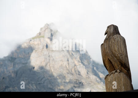 Aigle en bois Sculpture en Suisse avec une montagne (Dündenhorn) dans l'arrière-plan Banque D'Images