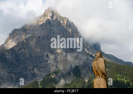 Aigle en bois Sculpture en Suisse avec une montagne (Dündenhorn) dans l'arrière-plan Banque D'Images