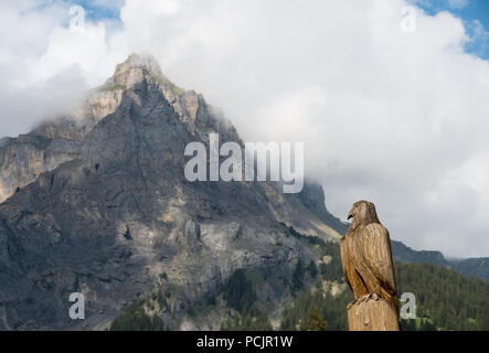 Aigle en bois Sculpture en Suisse avec une montagne (Dündenhorn) dans l'arrière-plan Banque D'Images