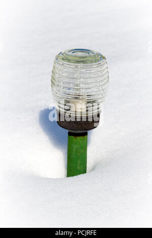 Une lanterne de jardin dans une congère de neige profonde. Banque D'Images