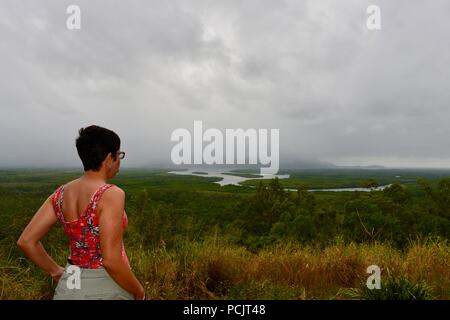 Une femme donne sur l'île de Hinchinbrook sur l'apparence d'un jour brumeux, vu de l'île de Hinchinbrook lookout, Cardwell, Queensland, Australie Banque D'Images