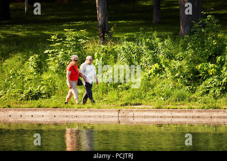 Montréal, Canada - 17 juin 2018 : Un vieux couple marche main dans la main près de l'étang dans le parc La Fontaine, Montréal, Canada. Usage éditorial. Banque D'Images