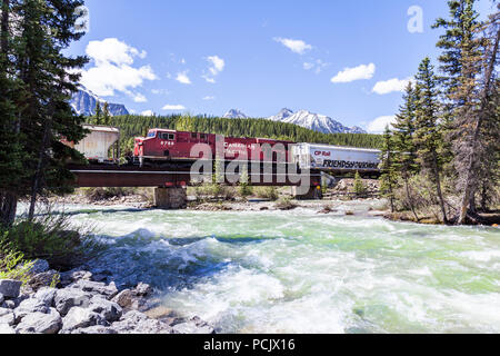 Un train de marchandises du Canadien Pacifique traversant la rivière Bow dans les Rocheuses à la ville de Lake Louise, Alberta, Canada Banque D'Images