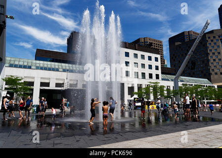 Rafraîchir les enfants jouant dans l'eau des fontaines dans la rue Jeanne Mance Montréal dans le quartier des divertissements. Prises au cours de la canicule de 2108. Banque D'Images