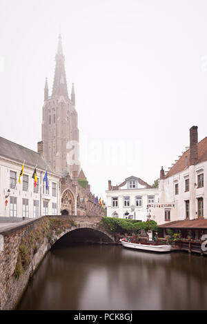 Vue de la tour de l'église de Notre Dame à Bruges lors d'un jour brumeux généralement avec reflet dans un canal. Long Shot de jour de l'exposition. Banque D'Images