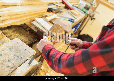 Male Carpenter à l'aide d'un burin avec un marteau Banque D'Images