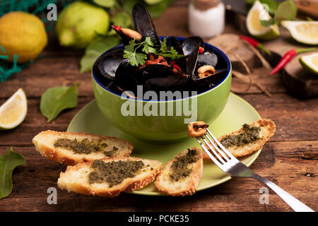 Les moules cuites dans un plat de cuisson sur fond de bois Banque D'Images