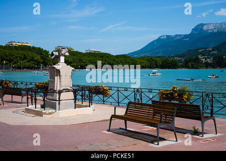 Lac d'Annecy rive avec banc et cadran solaire et Veyrier mont des Alpes montagnes en arrière-plan en France Banque D'Images