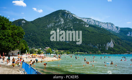 Annecy France, 30 juillet 2018 : Les gens profitant de la journée ensoleillée à Albigny plage et baignade dans le lac d'Annecy Alpes avec montagnes en arrière-plan en Fr Banque D'Images