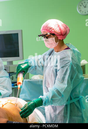 Chirurgie de liposuccion cosmétiques dans la salle d'opération, groupe de chirurgiens travaillant avec canule Banque D'Images