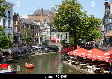 Les cafés en plein air à côté de l'Oude Gracht à Utrecht avec un bateau de tourisme dans le canal Banque D'Images