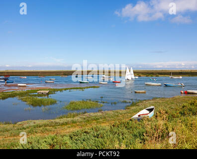 Une vue de petits bateaux à marée haute sur la côte nord du comté de Norfolk à Burnham Overy Staithe, Norfolk, Angleterre, Royaume-Uni, Europe. Banque D'Images