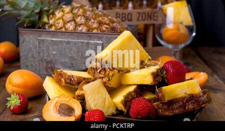 Jus de fruits tropicaux mûrs et cocktail à l'occasion d'une fête. Une boîte de bière et un fond de bois. Vintage photo. L'espace de copie, Banque D'Images