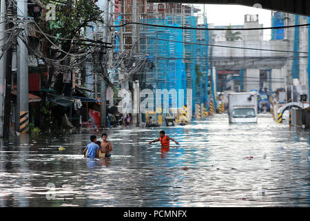 Quezon City, Philippines. 3e août 2018. Les résidents parcourir un chemin inondé après de fortes pluies de mousson à Quezon City, Metro Manila, Philippines, 3 août 2018. Plusieurs rues et zones résidentielles dans la région métropolitaine de Manille ont été immergés dans l'eau en raison de la mousson continue. Credit : Rouelle Umali/Xinhua/Alamy Live News Banque D'Images