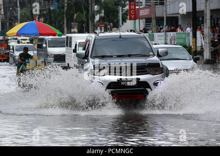 Quezon City, Philippines. 3e août 2018. Les véhicules se déplacent le long d'une route inondée après de fortes pluies de mousson à Quezon City, Metro Manila, Philippines, 3 août 2018. Plusieurs rues et zones résidentielles dans la région métropolitaine de Manille ont été immergés dans l'eau en raison de la mousson continue. Credit : Rouelle Umali/Xinhua/Alamy Live News Banque D'Images