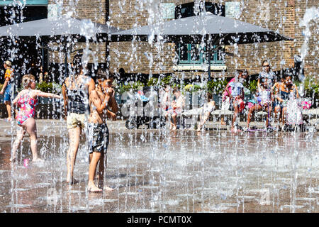 Les familles et les enfants se rafraîchissent dans les fontaines de Granary Square tandis que les températures montent, King's Cross, Londres, Royaume-Uni Banque D'Images