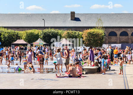 Les familles et les enfants se rafraîchissent dans les fontaines de Granary Square tandis que les températures montent, King's Cross, Londres, Royaume-Uni Banque D'Images