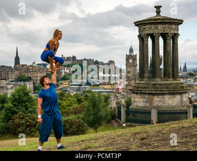 Edinburgh Fringe Festival, Édimbourg, Royaume-Uni. 3 août 2018. Calton Hill, Édimbourg, Écosse Royaume-Uni : une séance de photos pour à peine Troupe méthodique (BMT), un dispositif expérimental de cirque acrobatique. Fringe 2018 leur spectacle est appelée SHIFT. Un interprète masculin de tenir une grande interprète féminine dans l'air à côté de l'Dugald Stewart monument avec vue sur la ville Banque D'Images