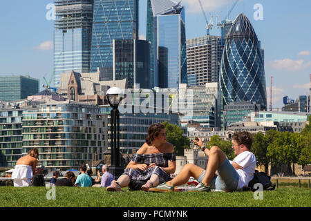 Parc des champs de potiers. Londres. UK, 3 août 2018 - Un couple assis sur l'herbe verte fraîche dans les champs Potters Park sur une autre journée très chaude dans la capitale. D'après le Met Office la canicule est d'continue au Royaume-Uni et dans certaines parties de l'Europe dans les prochains jours avec des températures record prévu. Credit : Dinendra Haria/Alamy Live News Banque D'Images