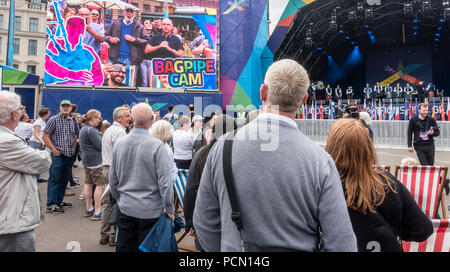 George Square, Glasgow ; l'Ecosse. 06Th August 2018. Les visiteurs au Festival 2018, à George Square, au centre de Glasgow. Les présentateurs ont encouragé les spectateurs à imiter la cornemuse et leurs efforts sont projetées sur un grand écran comme 'Cornemuse Cam', tandis qu'une partie de la jeunesse nationale Pipe Band de l'Écosse attend sur scène à effectuer. Le festival est organisé en parallèle avec les championnats européens, Glasgow 2018. George Square est un lieu libre avec plusieurs attractions virtuelles en direct et tous les jours. Le festival est organisé en parallèle avec le Championnat d'Europe ; Glasgow 2018. George Square est une Banque D'Images