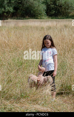 Petite fille dans Parc avec peluche Banque D'Images