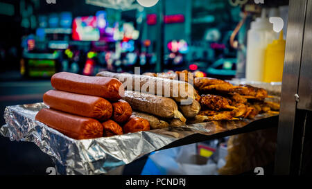 Brochettes de saucisses et quelques assis sur un papier aluminium à un poste à New York. Banque D'Images