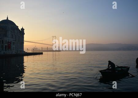 Lever du soleil à Istanbul alors qu'un pêcheur se prépare pour la pêche Banque D'Images