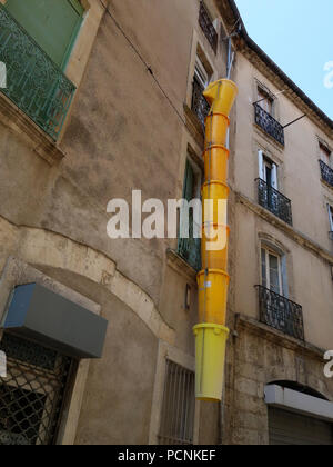 Les constructeurs jaune chute, le projet de construction d'orienter les ordures le long de la paroi de l'immeuble et en toute sécurité dans un camion pour être éliminés hors de l'emplacement Banque D'Images