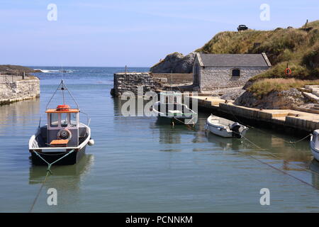 Port pittoresque de Ballintoy en Irlande du Nord avec petits bateaux amarrés en toute sécurité. Banque D'Images