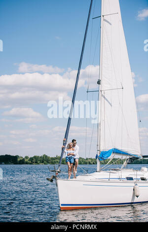 Beau jeune couple hugging tout en passant du temps ensemble on yacht Banque D'Images