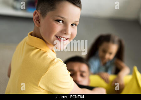La fermeture de la bouche des enfants père avec ruban noir à la maison, fils looking at camera Banque D'Images