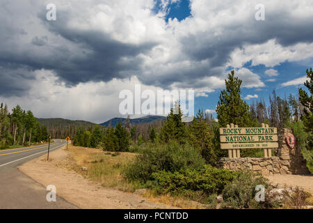 ROCKY MOUNTAIN NATIONAL PARK, CO-17 le 18 juillet : panneau d'entrée de parc, avec route menant au loin sur la gauche. Banque D'Images