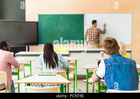 Vue arrière d'étudiants à l'écoute des enseignants Conférence au college Banque D'Images
