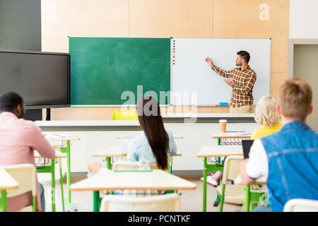 Vue arrière de l'écoute pour les enseignants étudiants multiethnique conférence au college Banque D'Images