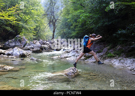 L'été sur la rivière mère, sautant d'un whileh rock traversant une rivière vierge, Slovénie, Europe Banque D'Images