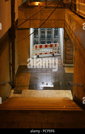 Les étapes d'un sombre tunnel de la station avec les flaques et les murs humides. Banque D'Images