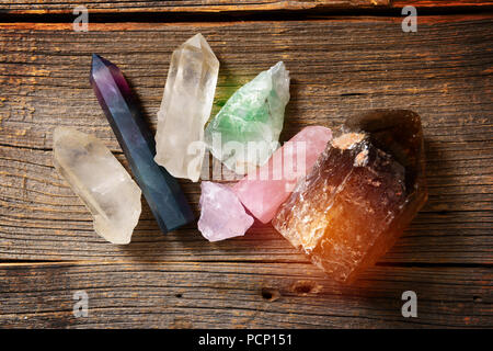 Plusieurs pierres semi-précieuses sur planche de bois fluorine, quartz, quartz fumé, quartz rose. Banque D'Images