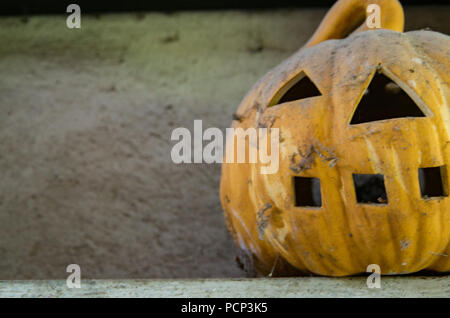 Vieux Jack O Lantern assis sur un plateau couvert de poussière Banque D'Images