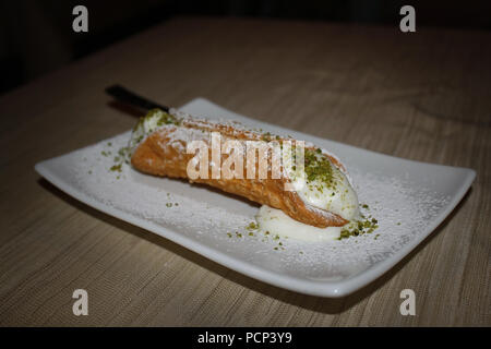 Cannoli siciliens traditionnels, la pâtisserie frite rempli de remplissage sucré crémeux contenant la ricotta. Banque D'Images