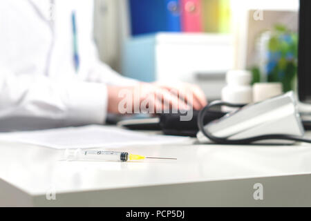 Vaccin de la grippe, ou influenza tourné ou test sanguin aiguille sur médecin table office. La médecine, l'insuline ou d'injection de vaccination ou d'une seringue. Banque D'Images