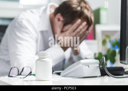 A insisté sur la face du couvercle médecin sous pression. Infirmière médecin fatigué, triste ou bouleversé doc. Medic pleurer dans le bureau de l'hôpital. Faute professionnelle médicale, le traitement d'erreur. Banque D'Images