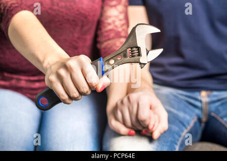 Problèmes de relation fixation concept. Couple holding hands en thérapie et counseling. Femme ou femme montrant un outil et une clé dynamométrique. Banque D'Images