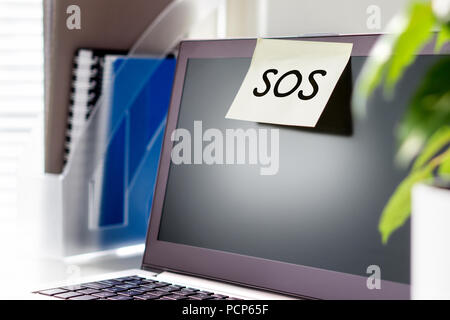 Questions et problèmes au travail. Mauvaise atmosphère et l'environnement au travail. Demande de l'aide. Sos texte sur un papier collant et post-it sur l'ordinateur portable. Banque D'Images