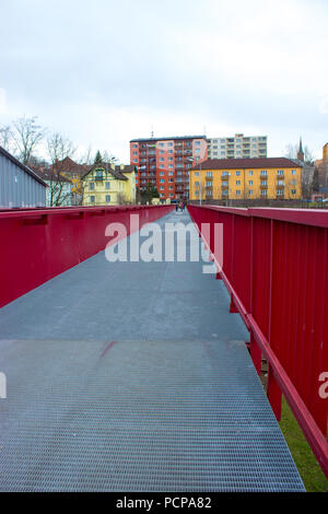 Rouge en acier pont sur le chemin de fer à Frydek Mistek en République tchèque. Dans l'arrière-plan sont la couleur du bloc d'appartements. Banque D'Images