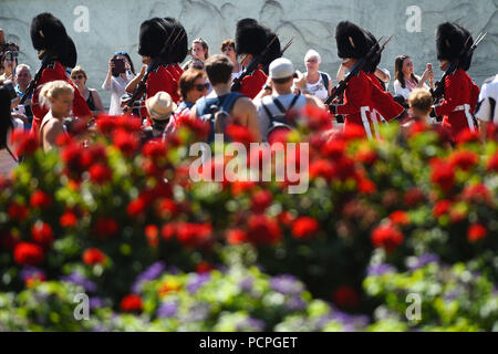 Spectateurs watch relève de la garde au Palais de Buckingham à Londres, qu'un autre souffle de temps chaud est mis à frapper certaines parties du Royaume-Uni. Banque D'Images