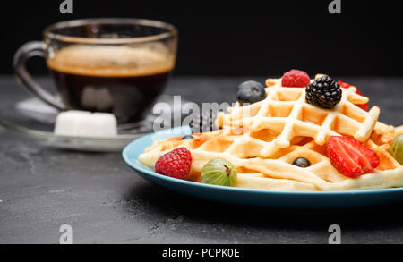 Photo de tasse de café avec des gaufrettes belges avec fraises, framboises Banque D'Images