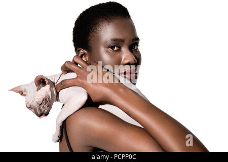 Beau young african american woman holding cat sphynx et looking at camera isolated on white Banque D'Images