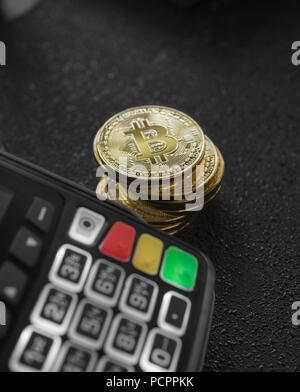 Une pile de pièces d'or et de terminal de point de Bitcoin. Les Bitcoins Cryptocurrency. E-commerce, affaires, finances, banque et concept paymant Banque D'Images