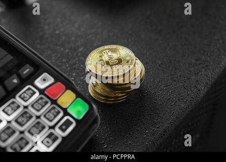 Une pile de pièces d'or et de terminal de point de Bitcoin. Les Bitcoins Cryptocurrency. E-commerce, affaires, finances, banque et concept paymant Banque D'Images