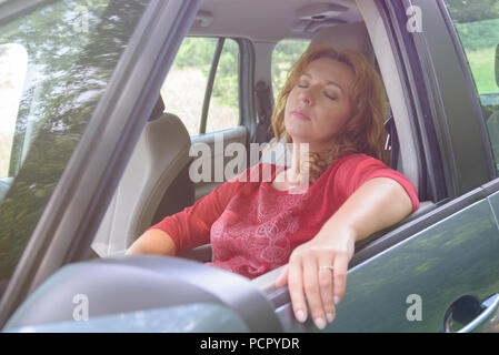 Femme pilote est au repos dans la voiture durant une pause voyage Banque D'Images